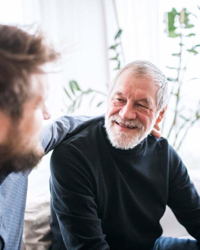Hipster son and his senior father at home. Hipster son and his senior father at home. Two generations indoors, having fun.